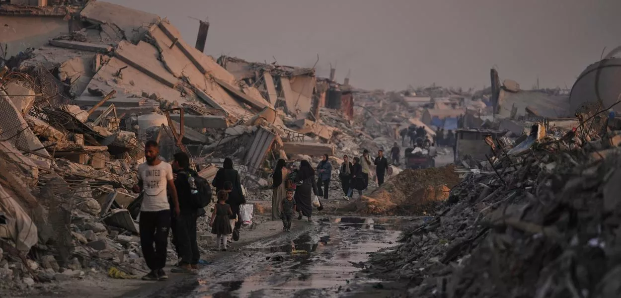 Palestinians walking through the ruins of Gaza City. (Photo: Jehad Alshrafi)