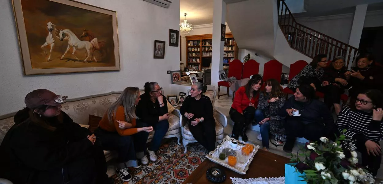 Tunisian lawyer and writer Sonia Dahmani (C) sits with family members at her home in Tunis on November 27, 2025 after her conditional release from prison. Dahmani, 60, was arrested by masked men in May 2024 and faced charges in several cases over her comments on radio and television denouncing racism in Tunisia. She was convicted in at least three cases in recent months. (Photo by FETHI BELAID / AFP) (Photo: FETHI BELAID)
