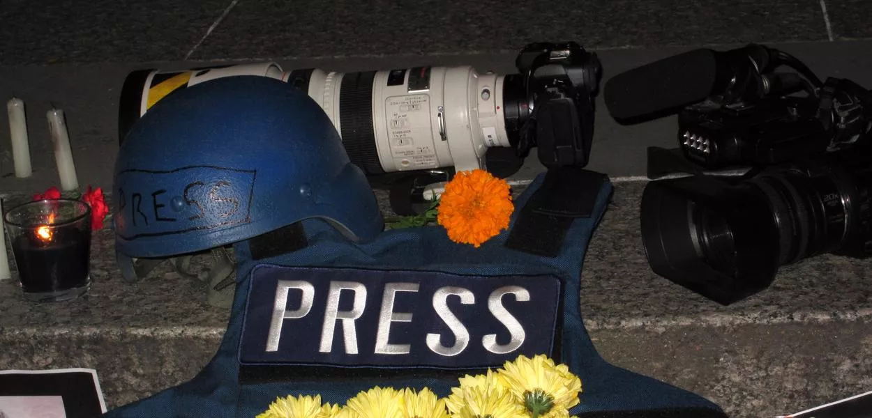 A helmet, cameras and a protective vest – equipment used by journalists working in war zones lies next to flowers and candles at a vigil in Foley Square. Sixty-seven journalists have been killed worldwide in connection with their work in the past 12 months. (Photo: Bruce Cotler/Zuma Press/dpa)