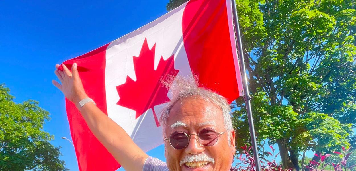 In this photo released by Dong Guangping, Dong Guangping poses for a photo with the Canadian flag after arriving in Toronto, Canada, on June 27, 2026.