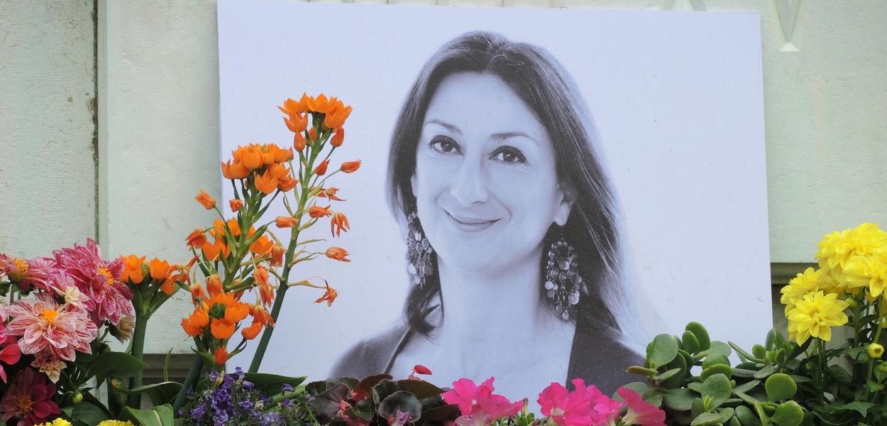 Candles and flowers have been laid in memory of the murdered Maltese journalist Daphne Caruana Galizia in front of a photograph of her outside the Palace of Justice in Valletta in 2018. (Photo: Lena Klimkeit/dpa)