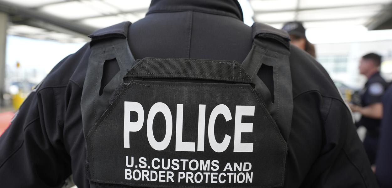 A Customs and Border Protection officer watches as then-U.S. Secretary of Homeland Security Noem passes through the San Ysidro Port of Entry. (Photo: Alex Brandon)