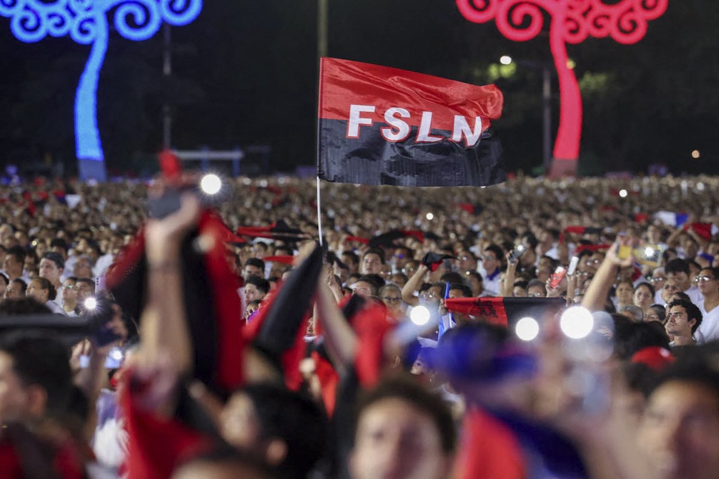 This handout picture released by Nicaragua's government via the official El 19 Digital news outlet shows a person waving a Sandinista National Liberation Front (FSLN) flag as people attend an event to commemorate the 47th anniversary of the Nicaraguan Revolution in Managua, on July 19, 2026. (Photo: Cesar Perez/ El 19 Digital/AFP)